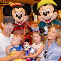 Christopher French, left, Ashley Tisdale, and two little girls pose with Minnie and Mickey Mouse