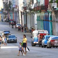 A woman with a girl passes a street in Havana