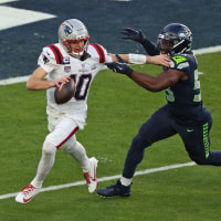 Seattle Seahawks' linebacker #53 Boye Mafe attempts to block New England Patriots' quarterback #10 Drake Maye 
