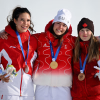 Gold medalist Mathilde Gremaud of Switzerland, on the podium stand with Silver medalist Ailing Eileen Gu of China and Bronze medalist Megan Oldham of Canada after winning the women's slopestyle final.