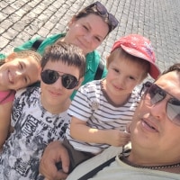 Oksana, center, and Nikita, left, pose with their children for a photo