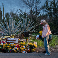 People stop at a makeshift memorial at the entrance to Nancy Guthrie's home on Feb. 12, 2026 in Tucson, Ariz.