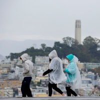 People wear rain ponchos;