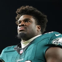 Jordan Davis looks off-camera while wearing football pads and a Philadelphia Eagles jersey.