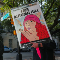 People hold signs in the street.
