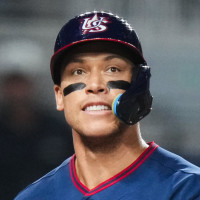 Aaron Judge on the baseball field walks while holding a bat