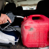 Roy Strohecker fills a red gas cannister