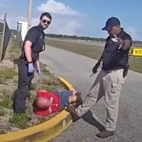 Bryan J. Parker lies on the ground after his arrest.