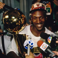 Michael Jordan #23, Shooting Guard and Small Forward for the Chicago Bulls, addresses the media holding the Larry O'Brien NBA Championship Trophy in the locker room after the Bulls win Game 6 of the NBA Finals and the Championship against the Seattle SuperSonics on 16th June 1996 at the United Center in Chicago, Illinois, United States.  The Chicago Bulls won the game 87 - 75. (Photo by Jonathan Daniel/Allsport/Getty Images)
