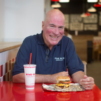 Jerry Murrell, founder of Five Guys, poses for a photograph inside the company's new hamburger outlet in London, U.K., on Tuesday, July 2, 2013.