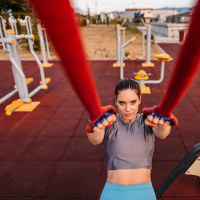 Young woman using expander working out outdoor