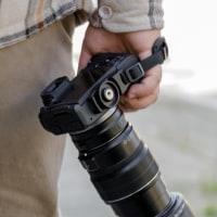 Hands Holding Dslr Telephoto Lens, Photographer Walking Sidewalk In Plaid Shirt And Khaki Pants, Camera Strap