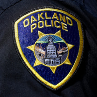 A close up view of an Oakland Police patch on the shoulder of a uniform