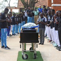 Ugandan soccer players pay homage around the coffin of SC Villa captain David Owori in Kampala on Aug. 6, 2026. 