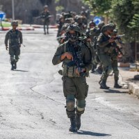 Israeli soldiers patrol a street in Qusra.