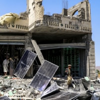 People inspect a heavily-damaged building after an air-strike in Yemen.