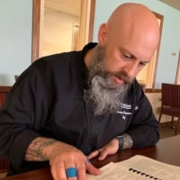 Chef Craig Bowerson reads recipes for his project.