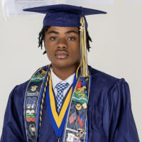 A young man wearing a cap and gown. 