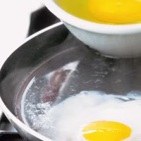 Eggs being poached in frying pan