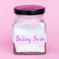 Jar of baking soda isolated on pink background.