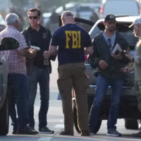 Law enforcement officials investigate the scene of a mass shooting at a Dollar General store, Saturday, Aug. 26, 2023, in Jacksonville, Fla.