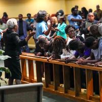 Image: Church members at the St. Paul A.M.E. Church pray with four Edward Waters University students, center, that attended a prayer service for the victims of a mass shooting, on Aug. 27, 2023, in Jacksonville, Fla.
