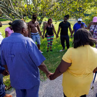 People gather for a prayer near the scene of a mass shooting in Jacksonville, Fla., on Aug. 26, 2023.