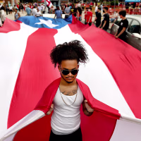 A participant helps carry the flag of Puerto Rico
