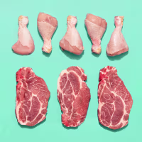 Top view with a variety of raw chicken and beef arranged on a green-mint table.