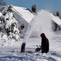 Gene Herbert, 80, begins digging out his home on Tuesday, Feb. 24, 2026, in Scituate, Mass.