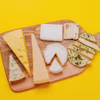 An assortment of various cheeses arranged on a board, highlighting different textures