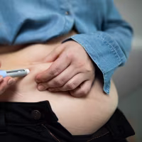Close-up of a person administering semaglutide injection for weight loss.