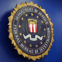 The logo of the Federal Bureau of Investigation hung on a blue wall next to an American flag