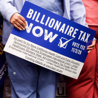 People hold signs calling for a billionaire tax