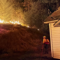 A firefighter battles the Fairview Fire in Spokane County, Wash.