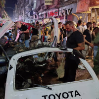 Syrian security personnel inspect damaged vehicles at the site of an explosion in the Jaramana , Syria.