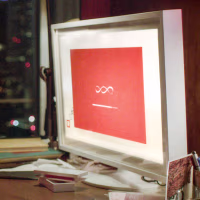 Joaquin Phoenix sits at a computer desk and looks at a loading screen on a computer screen