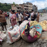 Residents stand next to piles of belongings in Trushuli, Nepal on Aug. 29, four days after devastating floods swept through the region, killing hundreds.