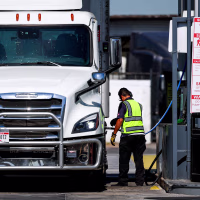 A truck driver refuels with diesel.