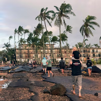 People walk past a damaged road