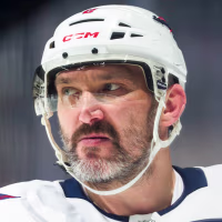 Alexander Ovechkin looks off while standing in the skating rink in full hockey uniform and a helmet