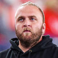 Steve Belichick stands with his hands in the pockets of his black sweatshirt