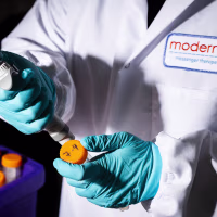 A researcher works in the lab at the Moderna headquarters in Cambridge, Mass.