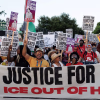 A crowd of protestors standing behind a banner reading JUSTICE FOR LORENZO! ICE OUT OF HOUSTON