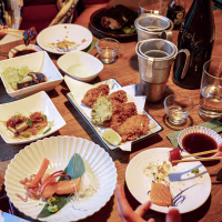 A top-down view of a crowded dining table at a Japanese restaurant.
