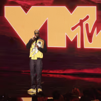 Snoop Dogg on stage in front of a giant VMA backdrop.
