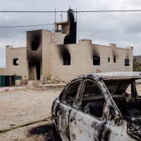 A destroyed car sits outside a burnt home the day after a number of Israeli settlers reportedly attacked people and property.