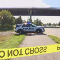 A police car sits outside by a highway