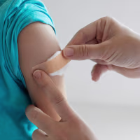 Unrecognizable doctor putting a patch on shoulder after successful vaccination