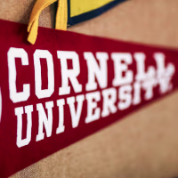 A red banner for Cornell University is displayed in a classroom